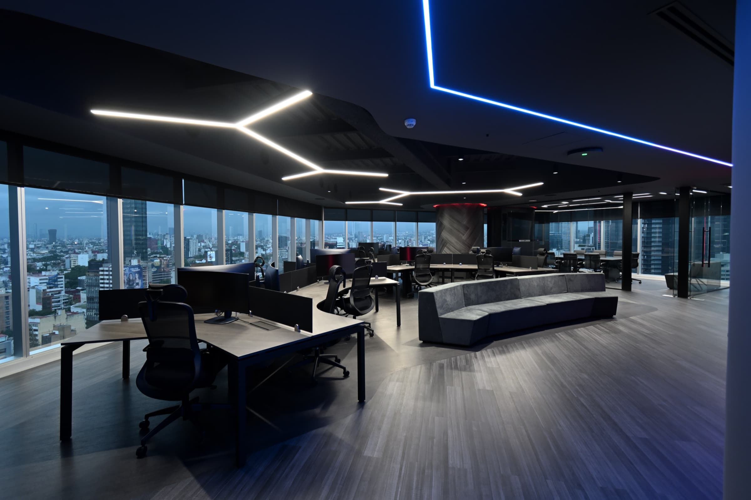 Área de trabajo abierta de noche con vista panorámica a la ciudad