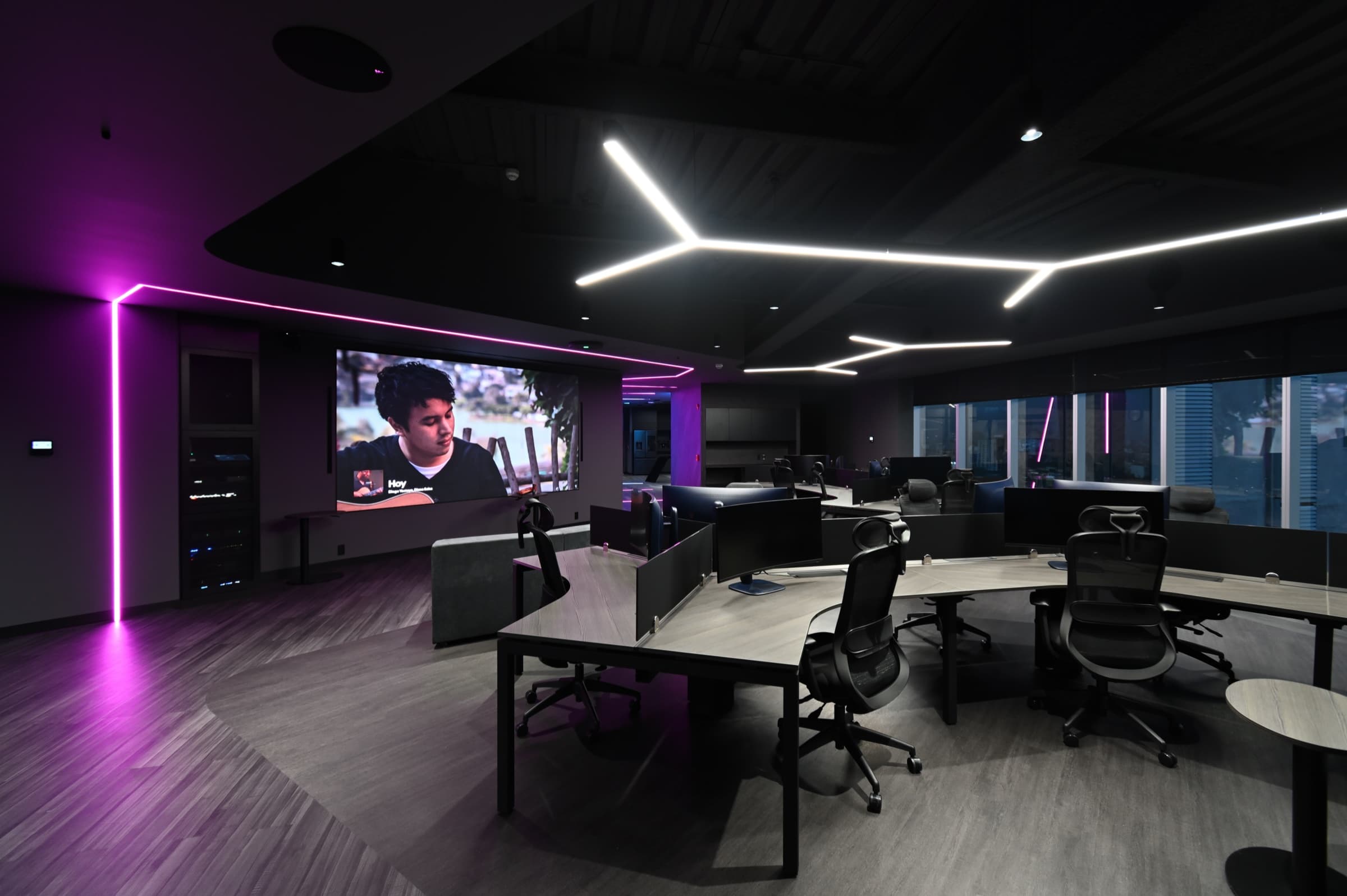 Sala de proyección con línea de luz magenta y pantalla
